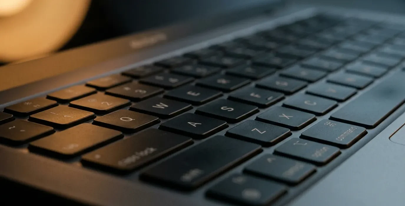 Gros plan sur les touches Q W E R T Y d'un clavier de portable en lumière rasante