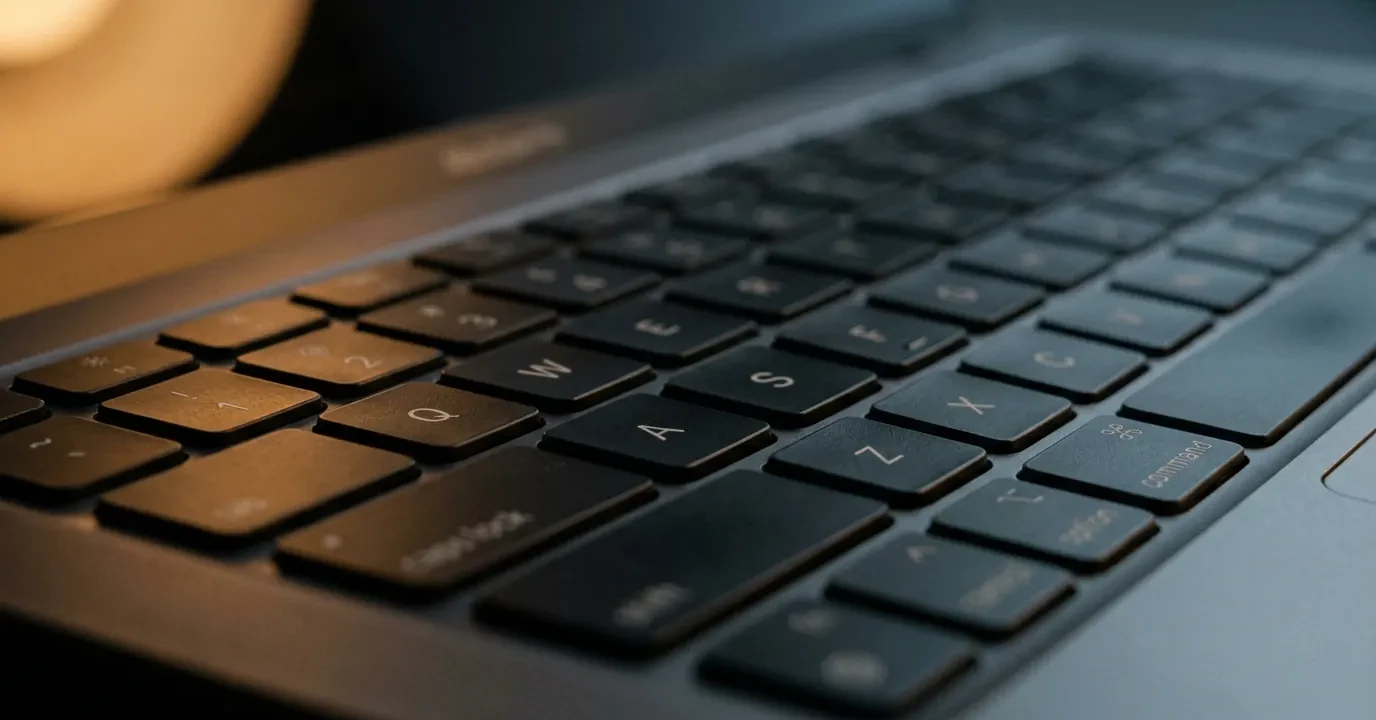 Gros plan sur les touches Q W E R T Y d'un clavier de portable en lumière rasante